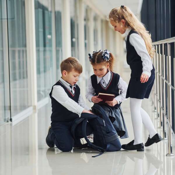 School kids in uniform together in corridor. Conception of education